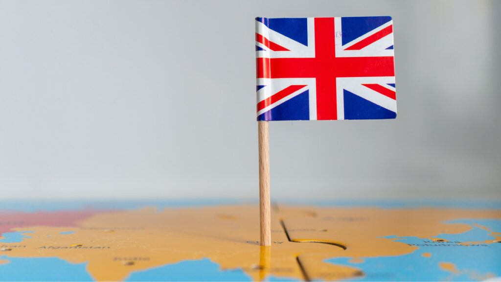 Small union jack on a wooden stick fixed on a globe