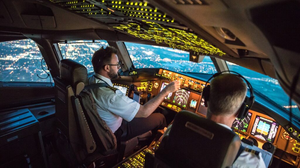 Two pilots at work during departure of Dallas Fort Worth Airport in United States of America. The view from the flight deck with high workload the beginning night through the wind shield