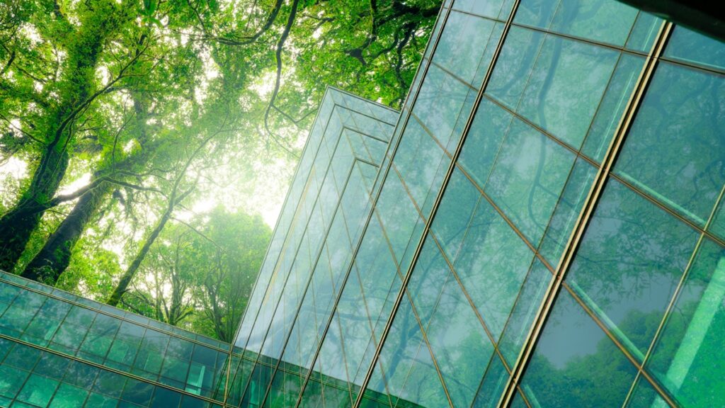 Eco-friendly building in modern city. Sustainable glass office building with trees for reducing CO2. Green architecture. Building with green environment. Sustainability corporate. Net zero emissions.