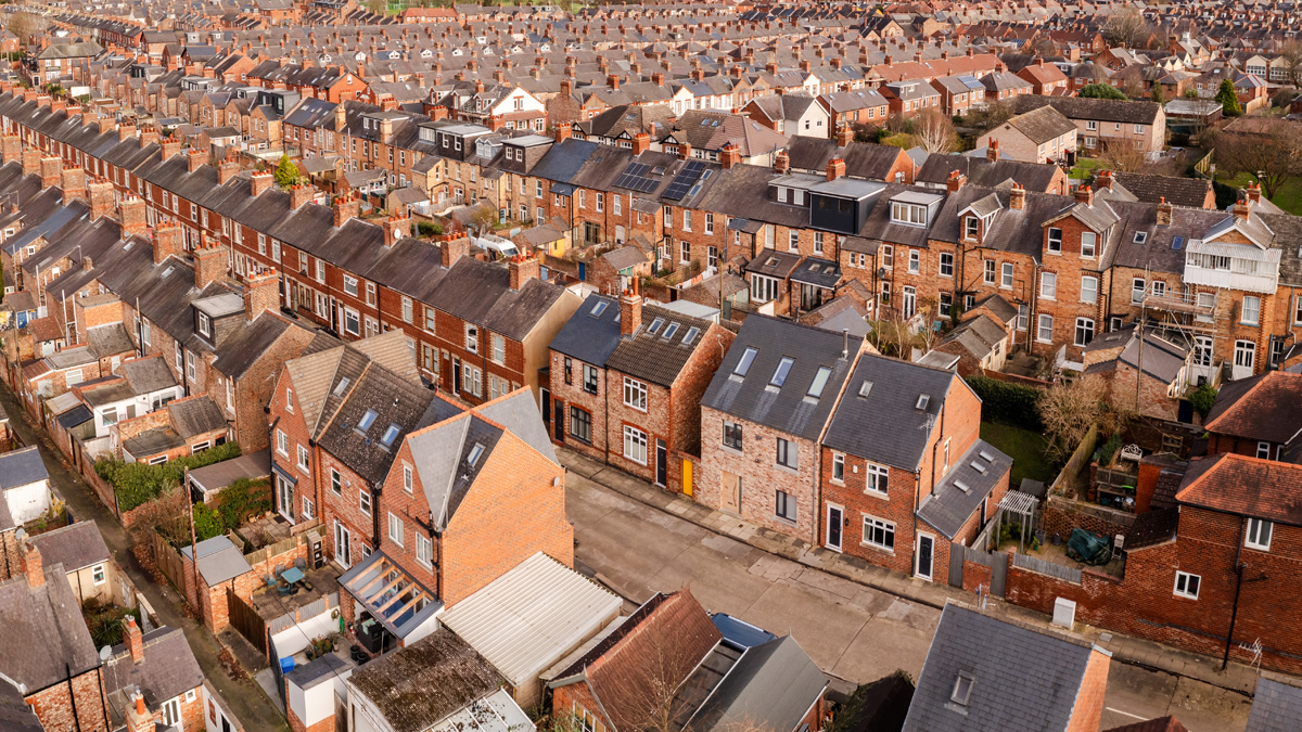 Aerial view above rows of back to back terraced houses on a large council estate