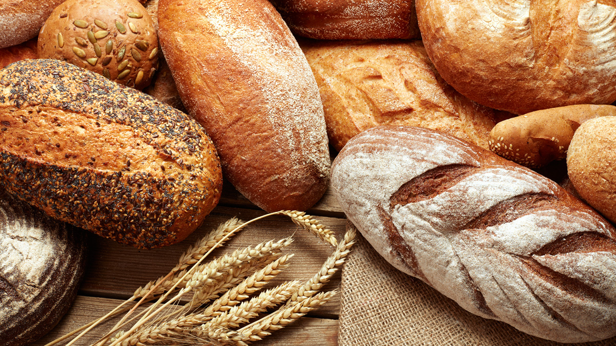 Assortment of baked bread on wooden background