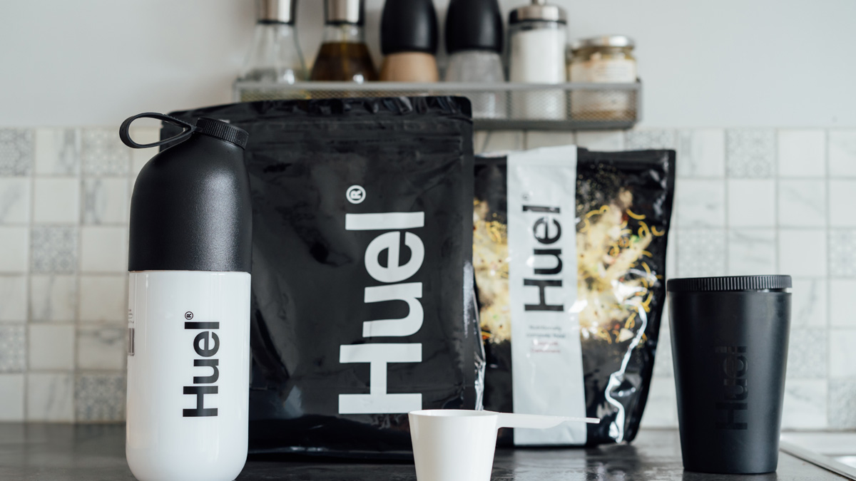 Branded Bags of meals, shaker and pot from Huel brand on the kitchen table