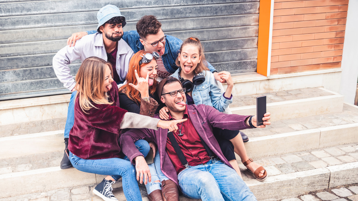 Happy millennial friends taking selfie with crazy funny faces outdoor