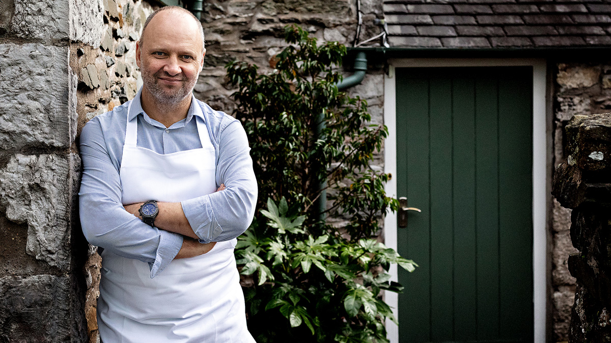 Simon Rogan standing against a wall