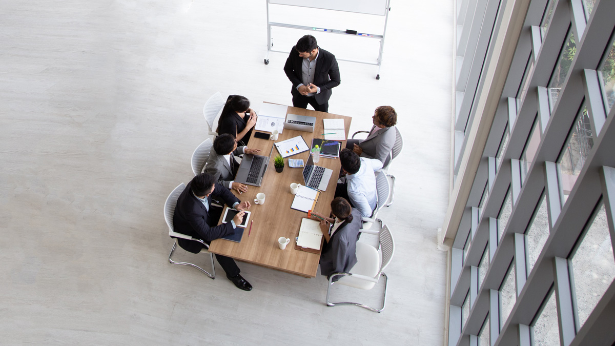 Aerial view with businesspeople sitting around a conference table