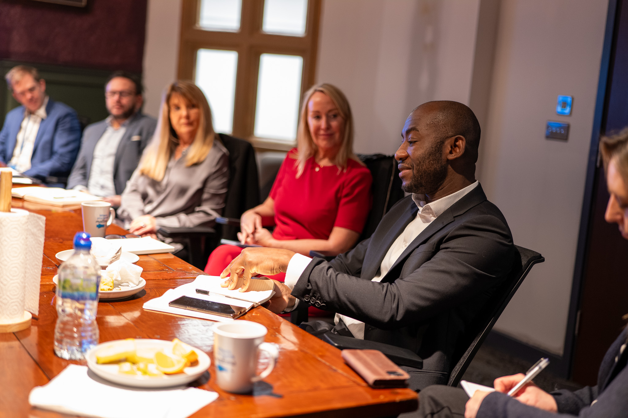 A group of professionals gather around a table in a meeting of minds.